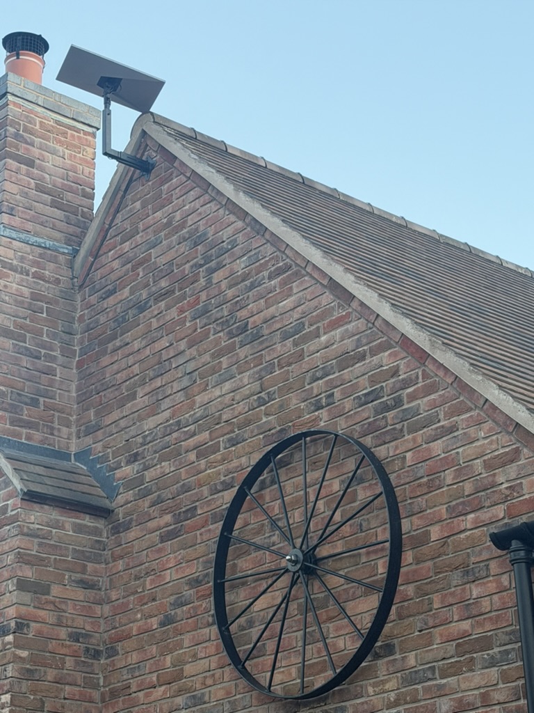 Starlink dish neatly mounted beside the chimney at a home in Lower Moor, Worcestershire